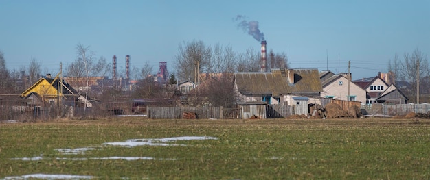 Maison de village sur fond d'usine industrielle