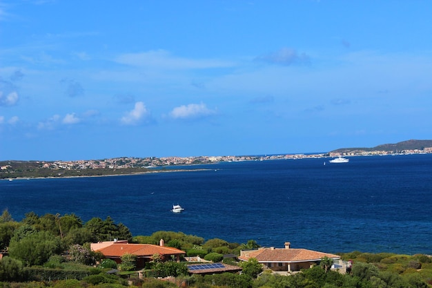 Photo des maisons au bord de la mer avec le port en arrière-plan