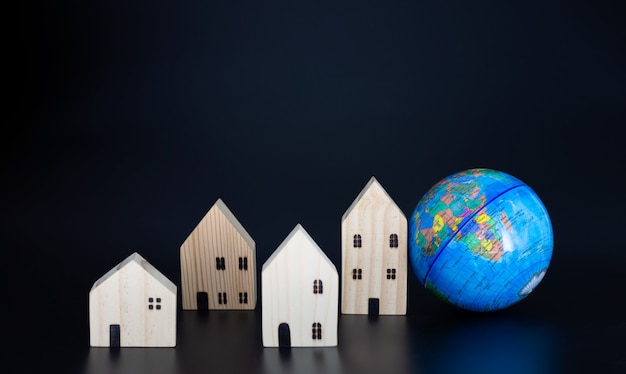 Maisons en bois modèles et globes miniatures Vierge sur fond noir Proposer le concept de coexistence dans le même monde