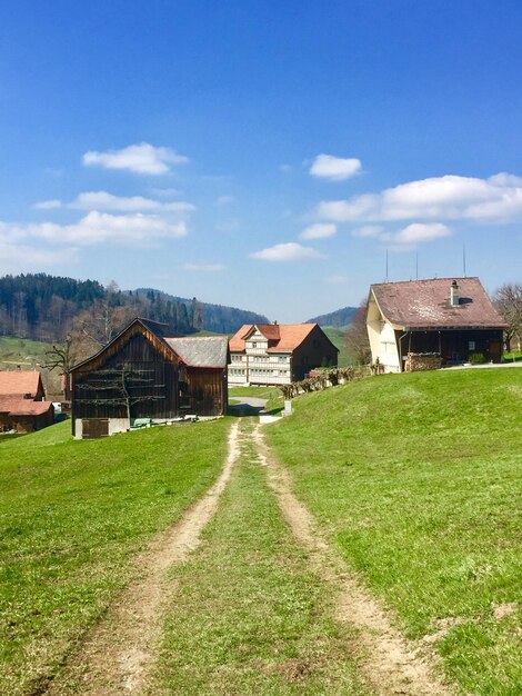 Des maisons sur le champ par des bâtiments contre le ciel