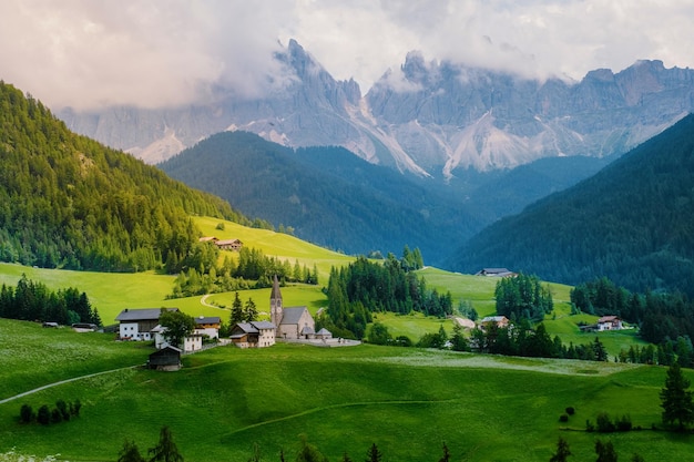 Des maisons sur le champ par les montagnes contre le ciel
