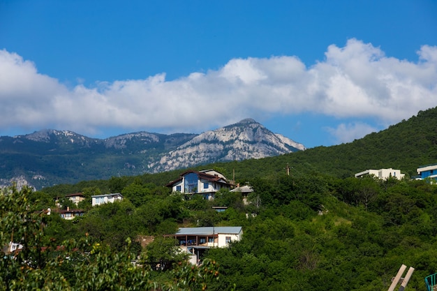 Maisons dans une vallée de montagne contre un ciel bleu.