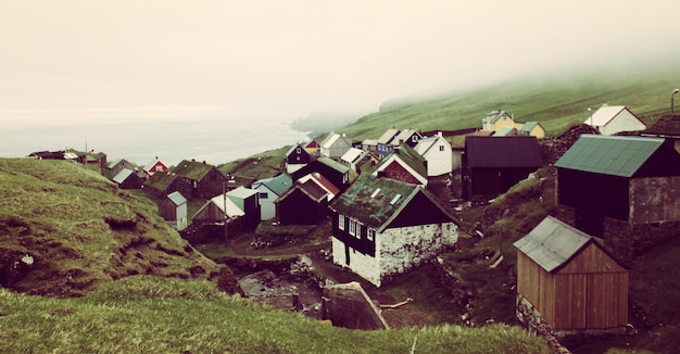 Photo des maisons sur la montagne par la mer contre le ciel