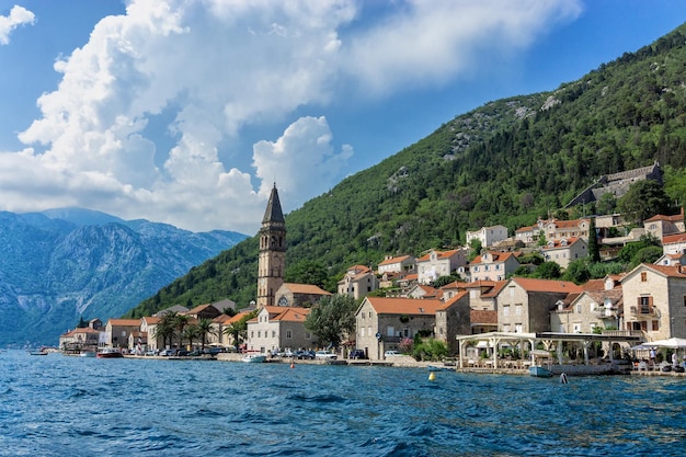 Des maisons et des montagnes sur la mer contre un ciel nuageux