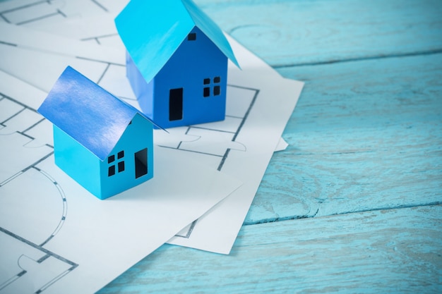 Maisons en papier bleu sur une vieille table en bois