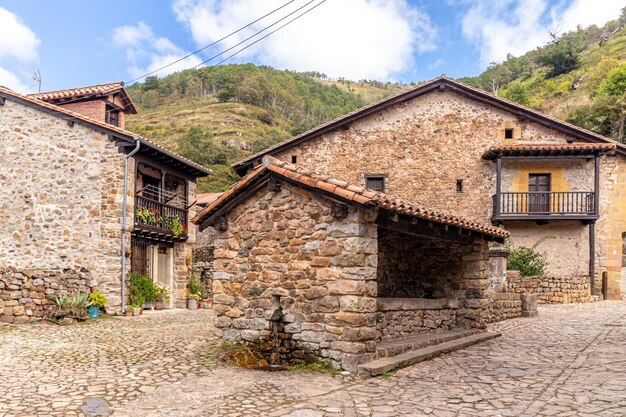 Maisons en pierre pittoresques avec des fleurs et des rues étroites dans l'un des plus beaux villages d'Espagne Barcena Mayor Cantabria