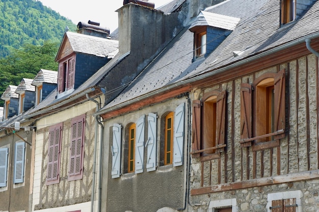 Maisons rustiques rétro avec de vieilles fenêtres et volets traditionnels du centre-ville dans le pittoresque village français d'Arreau France