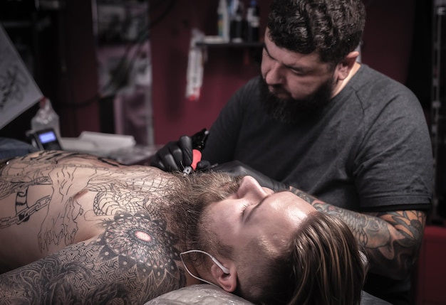 Maître de l'art du tatouage posant dans son salon