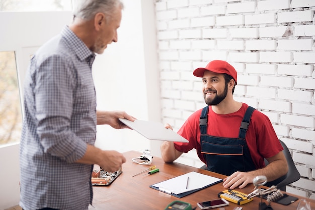 Le maître et le client s'entendent sur la réparation de l'appareil.