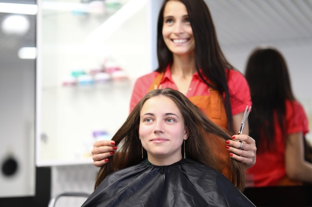 Maître coiffeur détient les cheveux du client dans un salon de beauté
