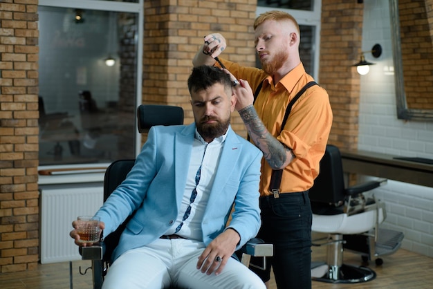 Le maître coiffeur fait la coiffure et le style avec des ciseaux et un peigne