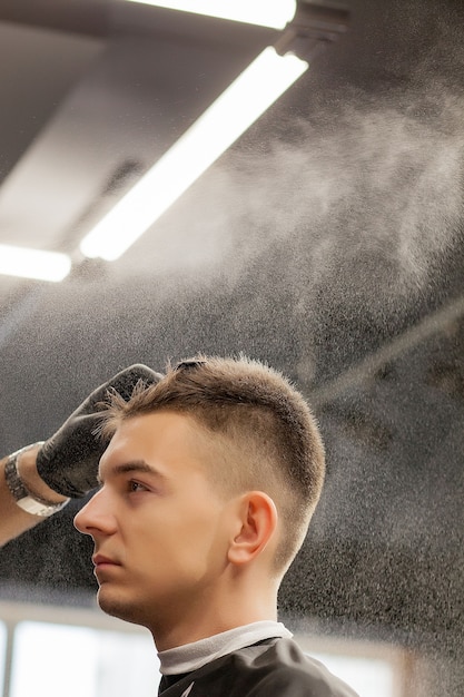 Le maître coiffeur fait la coiffure avec une tondeuse à cheveux. Salon de coiffure concept.