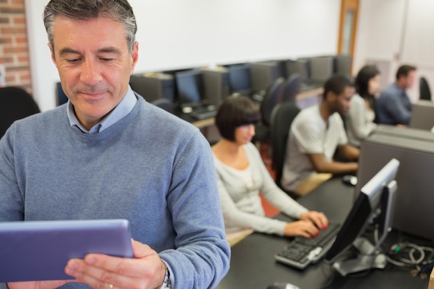 Maître debout tenant une tablette PC