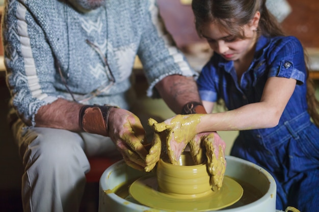 Le maître avec l&#39;enfant moule une cruche en argile.