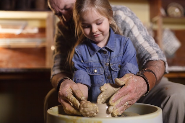 Le maître avec l&#39;enfant moule une cruche en argile.