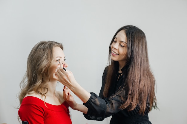 Le maître fait un beau maquillage blond dans un salon de beauté