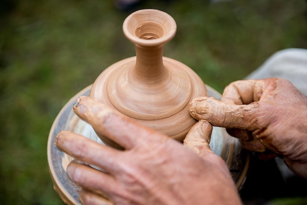 Maître fait une cruche d'argile. Pichet sur tour de potier. Un homme travaillant sur un tour de potier.