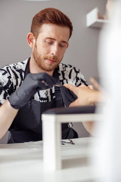 Maître manucure professionnel travaillant sur les ongles dans le salon