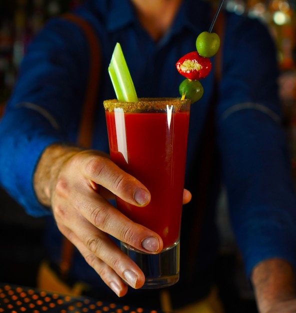 Un maître mixologue présente fièrement le classique Bloody Mary