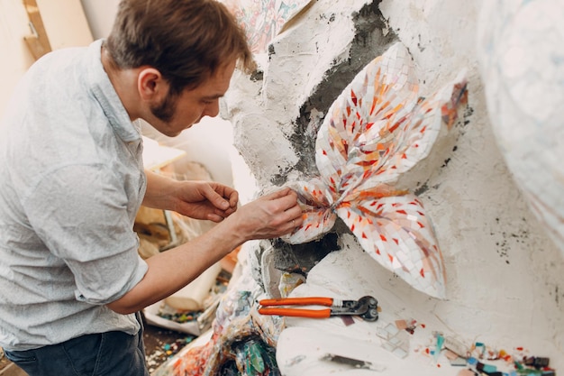 Maître de mosaïques en milieu de travail faisant panneau de mosaïque de verre smalt Homme mosaïste au travail