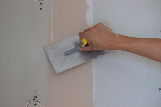 Le maître plâtre les murs et le plafond.