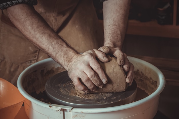 Maître potier mâle adulte écrasant l'argile