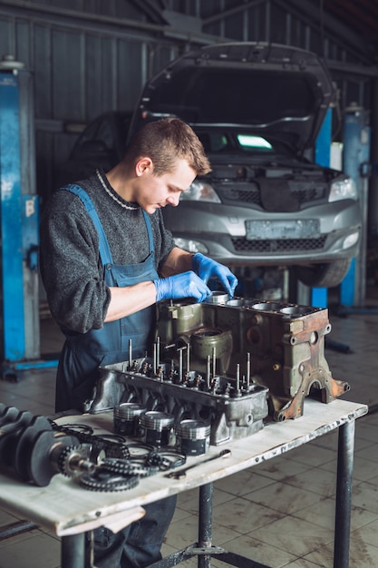 Le maître récupère un moteur reconstruit pour la voiture.