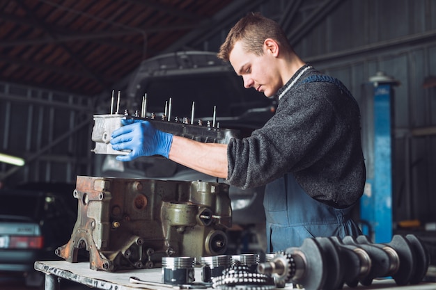 Le maître récupère un moteur reconstruit pour la voiture.