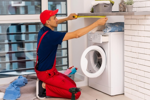 Le maître répare la machine à laver cassée