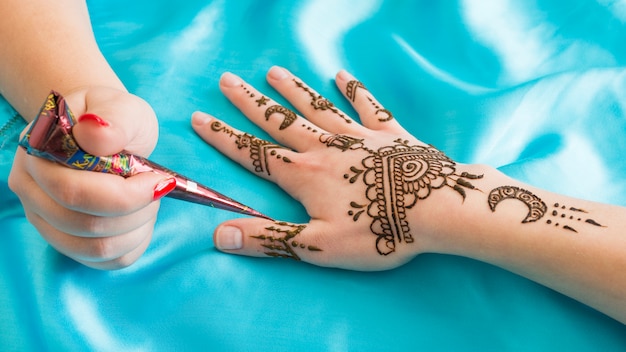 Photo maître tatouage merveilleux mehndi sur la main de la femme