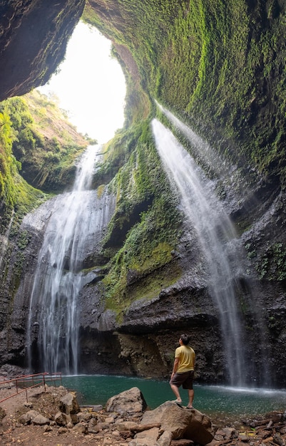 Majestueuse cascade qui coule sur la falaise rocheuse dans la forêt tropicale