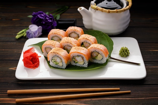 Maki sushi kimono avec décor sur une assiette sur un fond en bois