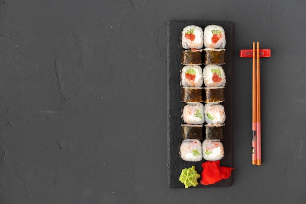 Maki sushi roll sur plaque de pierre noire vue de dessus