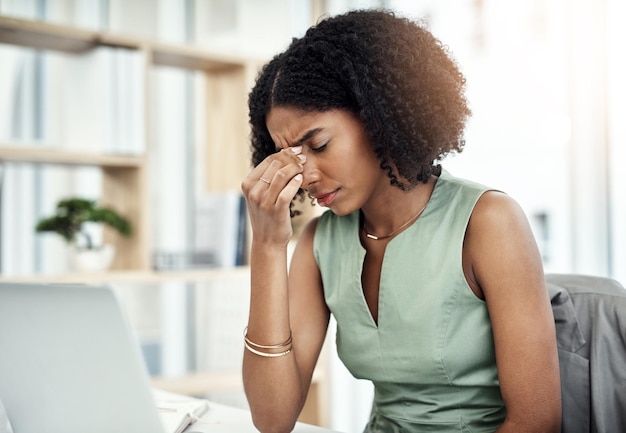 Photo ce mal de tête entrave sa productivité photo recadrée d'une jeune femme d'affaires séduisante souffrant d'un mal de tête alors qu'elle était assise à son bureau au bureau