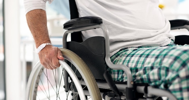 Malade en fauteuil roulant et gros plan d'un patient à l'hôpital après un diagnostic, un traitement ou une intervention chirurgicale Soins médicaux et zoom d'un homme âgé handicapé dans une clinique de soins médicaux ou de réadaptation