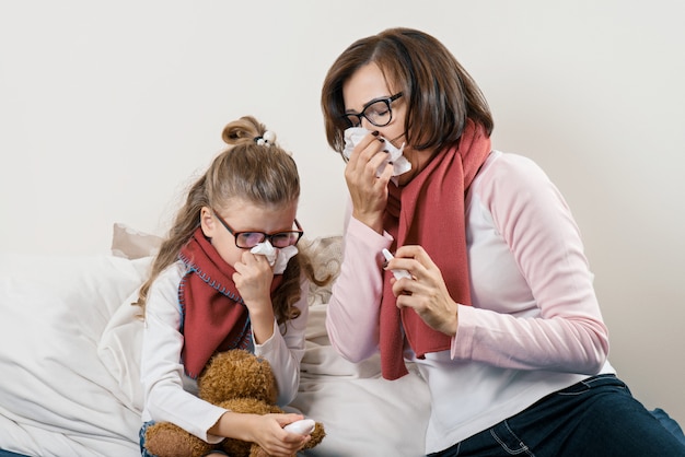 Malade mère et enfant éternuant dans un mouchoir