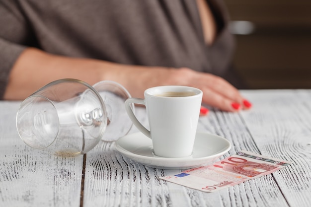 Maladie de l'alcoolisme montrant un verre de whisky vide avec une femme les mains sur le visage déprimé sur le verre