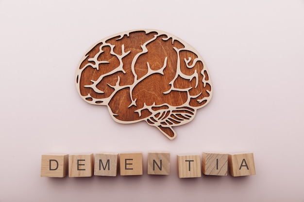 La maladie d'Alzheimer, la démence et le concept de santé mentale cerveau et cubes en bois avec mot démence