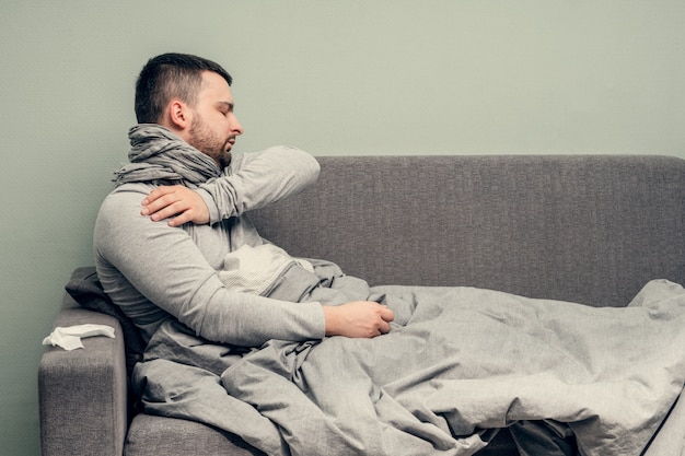 Maladie. Bravo à la maison. Un jeune homme est malade, est soigné à domicile. Se mouche dans une serviette, nez qui coule. Infection, épidémie, porteur de bacilles.