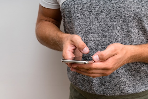 Mâle étudiant Mains Tapant Un Message Sur Un Téléphone Intelligent.