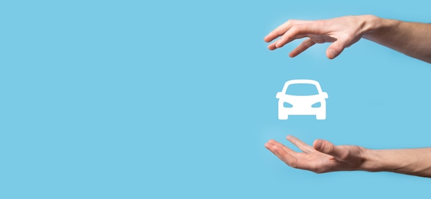 Mâle main tenant l'icône automatique de voiture sur fond bleu. Composition de la bannière large Assurances automobiles et concepts de dispense de dommages par collision.