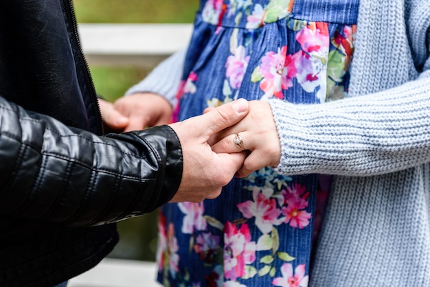 Mâle main tenant la main de sa femme enceinte. Femme enceinte étreignant le ventre.