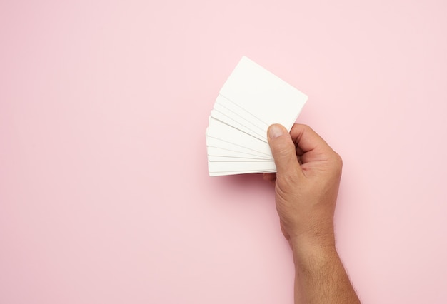 Mâle main tenant une pile de cartes de visite blanches vierges, espace copie