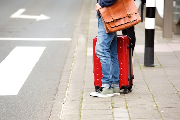 Mâle voyageur debout près de la rue avec valise