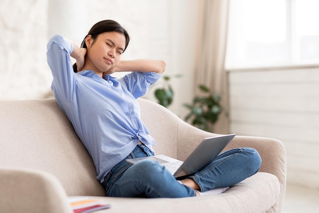 Malheureuse femme asiatique pigiste se frottant le cou