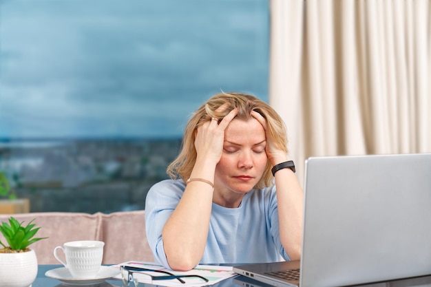 Malheureuse femme fatiguée au bureau à domicile travaillant avec un ordinateur portable stress dépression solitude fatigue burnout