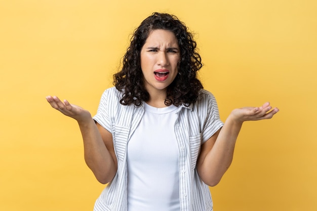 Malheureuse femme stressée debout les bras levés et demandant d'exprimer des émotions négatives