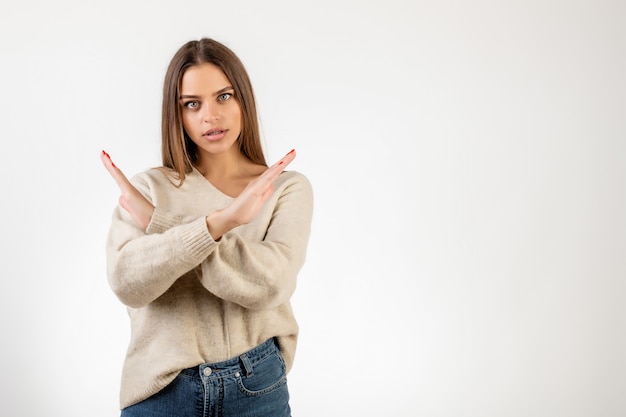 Malheureuse femme tenant la main croisée en disant non isolé sur blanc