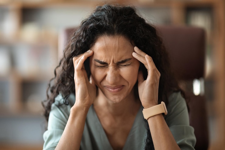Photo malheureuse jeune femme souffrant de migraine en travaillant