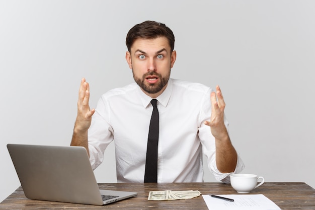 Malheureux homme travaillant au bureau, regardant la caméra, vue de face, isolé sur blanc.